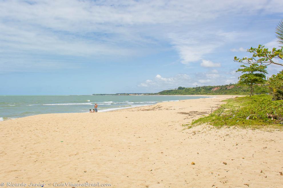 Imagem de três amigos nas areias da Praia de Curuípe.